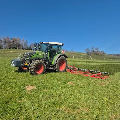 Fendt 211 Vario im Einsatz mit 8 Meter Wiesenegge und Striegel